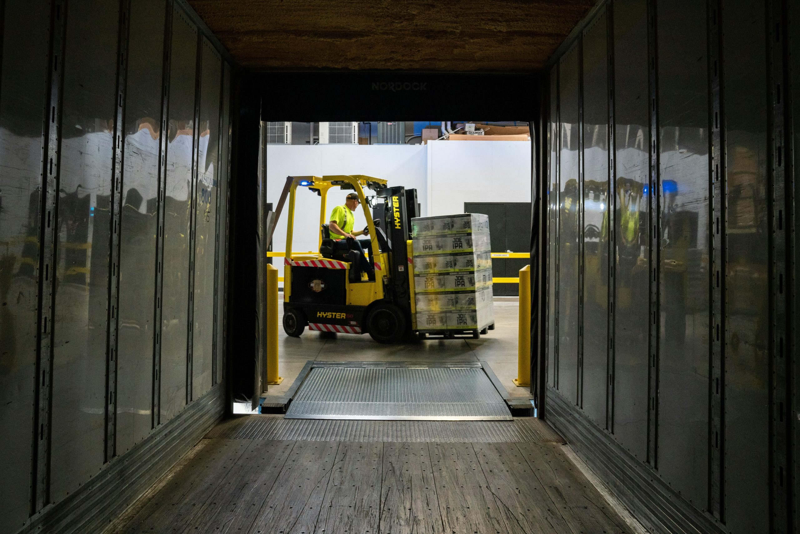 Inbound freight being unloaded by forklift at a warehouse dock, illustrating receiving, inventory intake, and execution visibility across the supply chain.